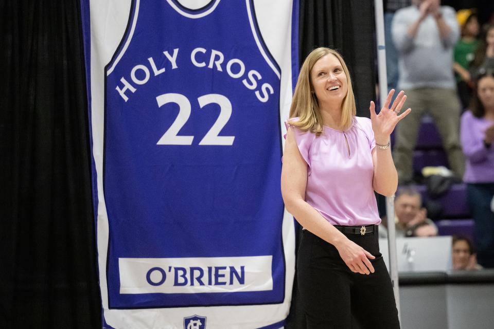 Amy O'Brien Davagian '99, stands with her jersey during Saturday's ceremony retiring the numbers of former Holy Cross female basketball players.