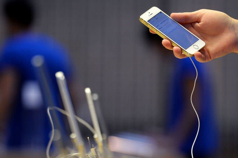 An employee prepares a display iPhone 5S's at the Apple store in preparation for opening ahead of the iPhone 5S and 5C going on sale in central London on September 20, 2013