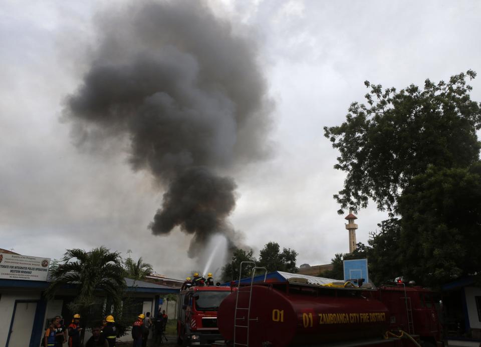 Smoke rises after a local government town hall occupied by Muslim rebels got burnt during fighting between government soldiers and the rebels in downtown Zamboanga September 11, 2013. (REUTERS/Erik De Castro)