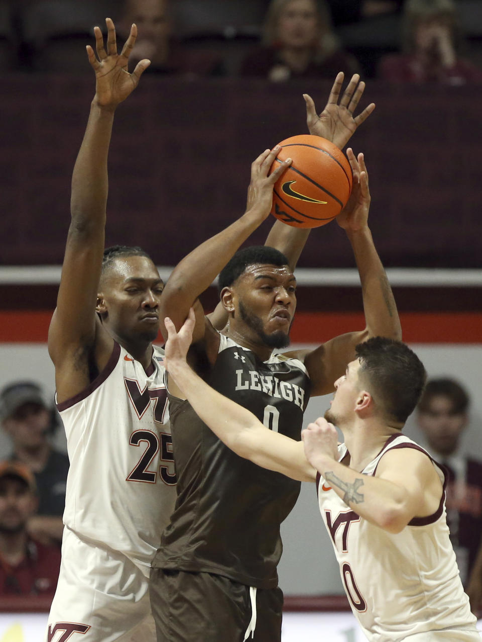 Lehigh's Jakob Alamudun, center, is guarded by Virginia Tech's Justyn Mutts (25) and Hunter Cattoor (0) during the first half of an NCAA college basketball game Thursday, Nov. 10, 2022, in Blacksburg, Va. (Matt Gentry/The Roanoke Times via AP)