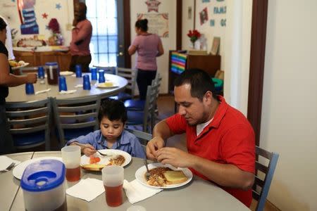 Walter Armando Jimenez Melendez, an asylum seeker from El Salvador, arrives with his four year-old son Jeremy at La Posada Providencia shelter in San Benito, Texas, U.S., shortly after he said they were reunited following 48 days of separation while in detention July 10, 2018. REUTERS/Loren Elliott