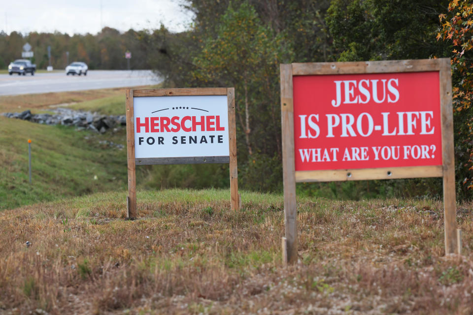 Campaign signs next to a road. One reads Herschel for Senate. The other reads Jesus is pro-life, what are you for?