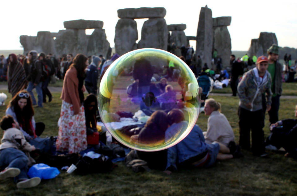 AMESBURY, ENGLAND - JUNE 21:  Bubbles float past as revellers watch as the midsummer sun rises just after dawn over the megalithic monument of Stonehenge on June 21, 2010 on Salisbury Plain, England. (Photo by Matt Cardy/Getty Images)