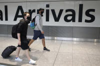 Passengers arrive at Heathrow Airport, in London, Sunday July 26, 2020. The British government has announced 14-day quarantine restrictions from Sunday, for people arriving into England from certain countries including Spain, after Covid-19 second wave fears saw the European country struck off the UK's safe list. (Andrew Matthews/PA via AP)