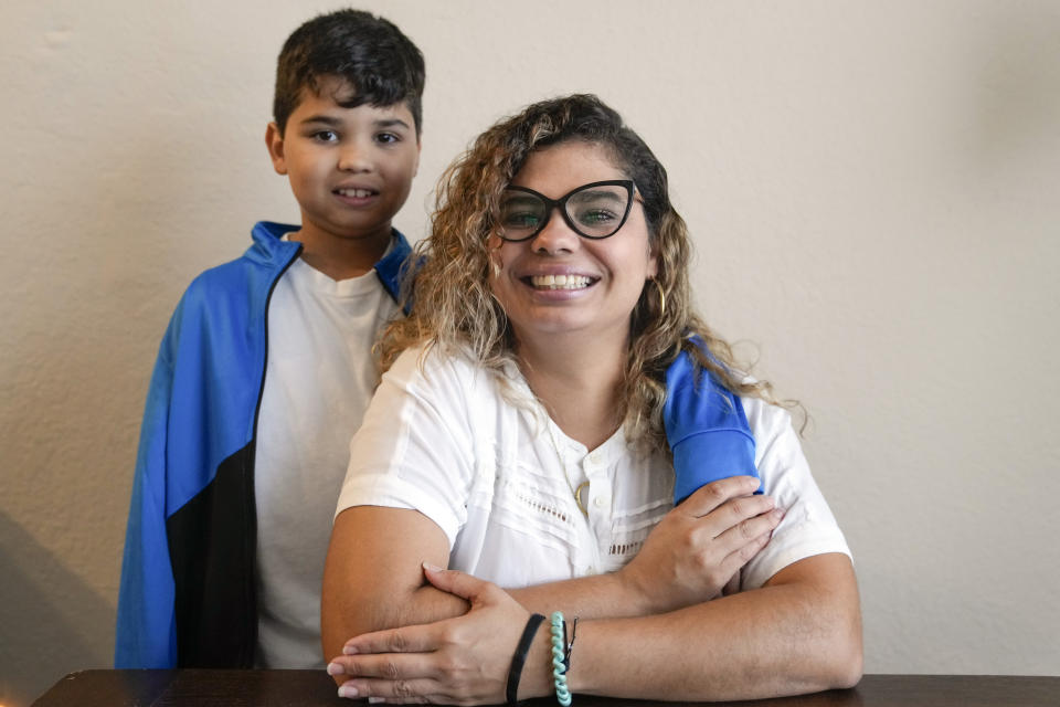 Caren Anez poses with her son Lucas Tello, 10, at her apartment, Wednesday, Sept. 27, 2023, in Orlando, Fla. Anez and family, from Venezuela, are seeking TPS, Temporary Protected Status, that would allow them to have a temporary legal status, request work authorization and protection from deportation. (AP Photo/John Raoux)