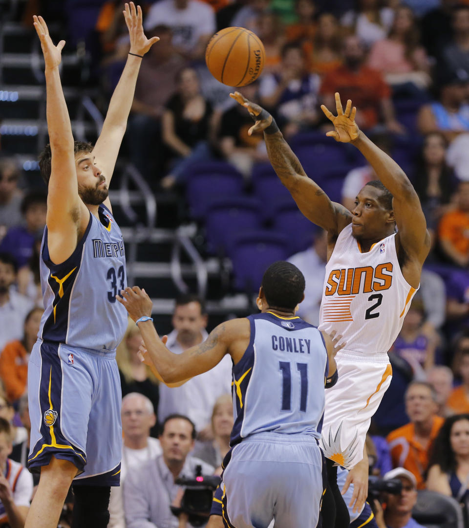 Phoenix Suns' Eric Bledsoe (2) passes as Memphis Grizzlies' Marc Gasol, of Spain, left, and Mike Conley (11) defends during the first half of an NBA basketball game, Monday, April 14, 2014, in Phoenix. (AP Photo/Matt York)