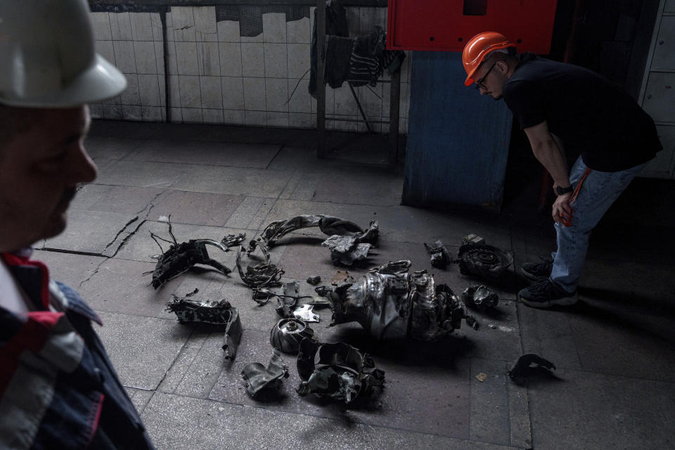 A man looks on fragments of a Russian rocket that hit a thermal power plant in Ukraine, Tuesday, May 21, 2024. (AP Photo/Evgeniy Maloletka)