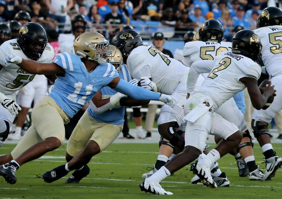 UCLA defensive lineman Gabriel Murphy pursues Colorado quarterback Shedeur Sanders for a sack at the Rose Bowl