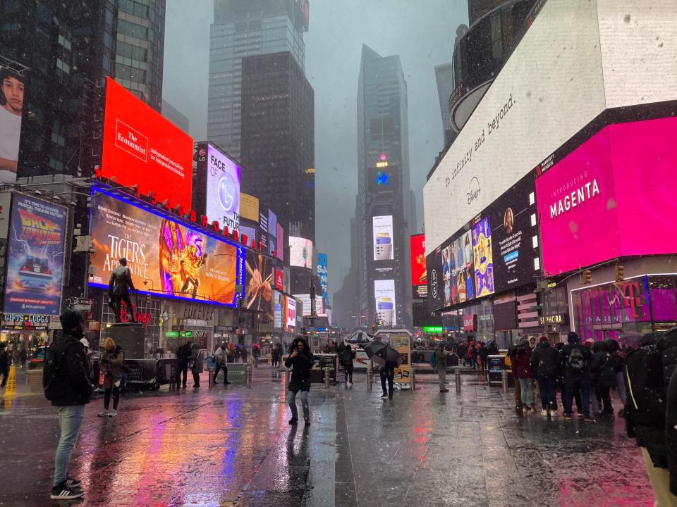 Tourists braved snow flurries and slush in Times Square as a Nor'easter dumped snow over New York and much of the Northeast on Tuesday.