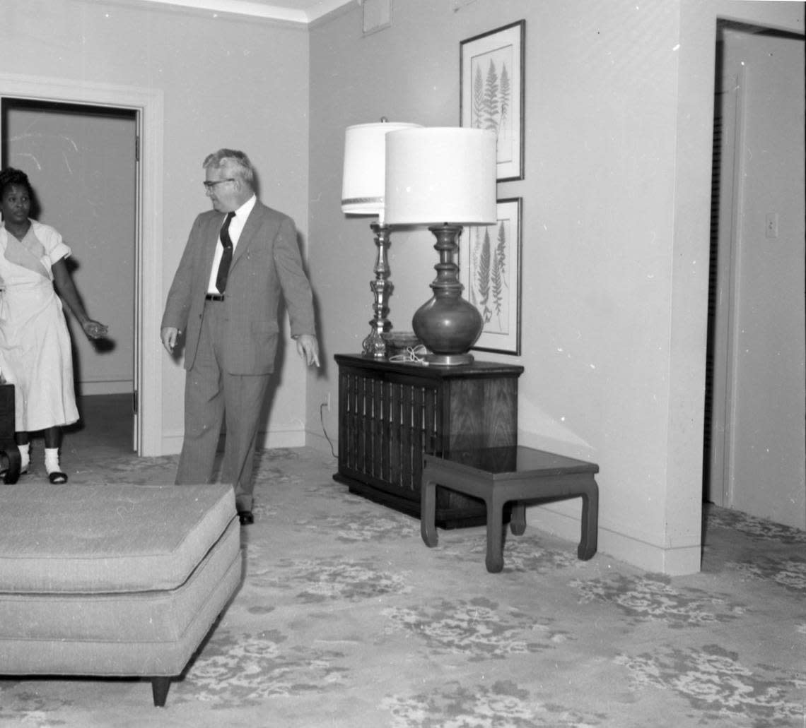 A.D. Rials, assistant manager of Hotel Texas, in Suite 850 living room with maid, being prepared for visit by President and Mrs. John F. Kennedy, Nov. 19, 1963