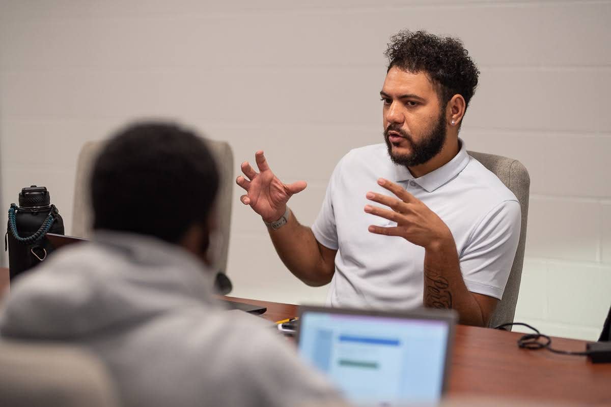 Isiah Caldwell, who teaches English at Crooked Oak Middle School, helps high school seniors fill out their application to attend the University of Oklahoma.