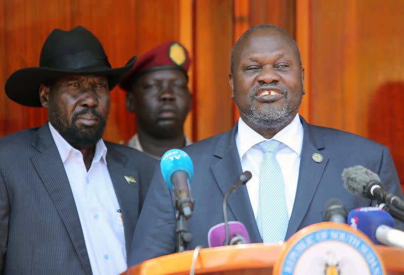 South Sudan's ex-vice President and former rebel leader Riek Machar flanked by President Salva Kiir Mayardit address a news conference at the State House in Juba