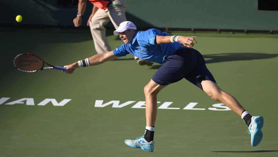John Isner reaches to return a shot to Ernests Gulbis, of Latvia, during their quarterfinal match at the BNP Paribas Open tennis tournament, Friday, March 14, 2014, in Indian Wells, Calif. (AP Photo/Mark J. Terrill)