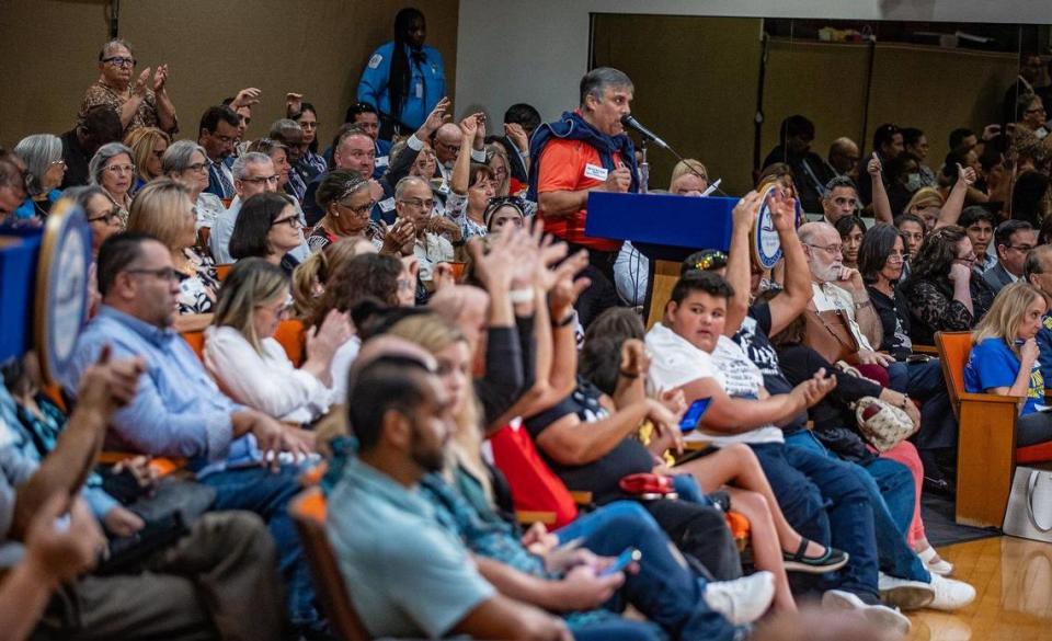 Attendees at the Miami-Dade School Board meeting on Wednesday, Sept. 6, 2023, wave hands in support of a speaker who opposed the recognition of October as Lesbian, Gay, Bisexual, Transgender and Queer History Month.