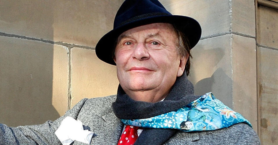 Barry Humphries with a black hat and a scarf