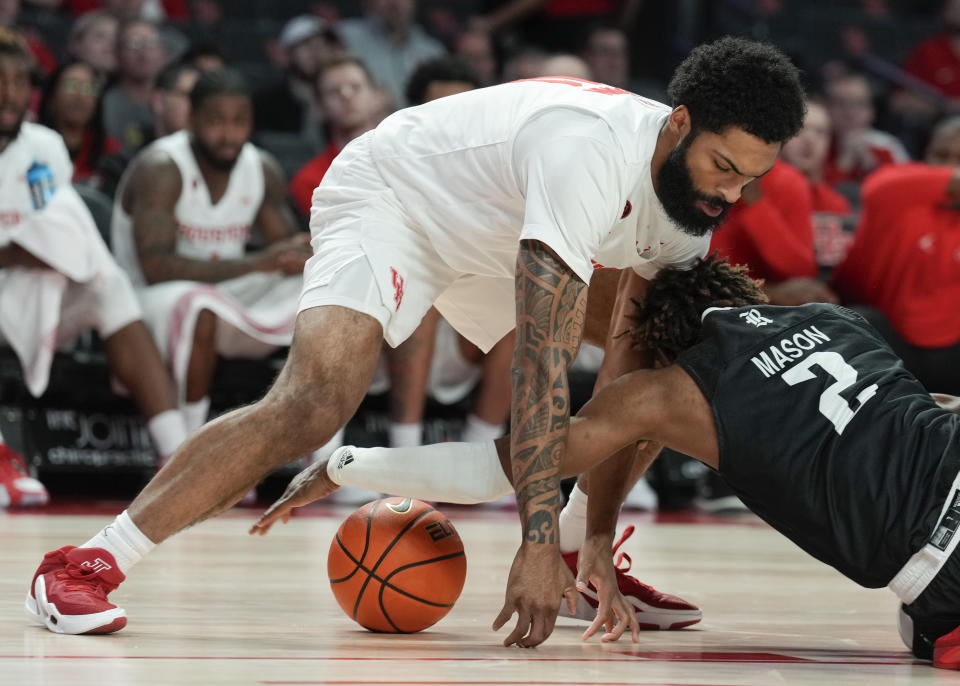 Houston guard Damian Dunn (11) dives after a loose ball along with Rice guard Mekhi Mason (2) during the first half of an NCAA college basketball game at the Fertitta Center, Wednesday, Dec. 6, 2023, in Houston. (Jason Fochtman/Houston Chronicle via AP)