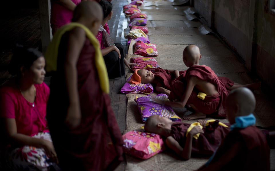In this April 8, 2014 photo, newly ordained Buddhist novices sit on mats at a Buddhist monastery in suburbs of Yangon, Myanmar. In addition to learning the basic tenants of their faith, it serves as a sort of spiritual credit for their parents, helping emancipate them from a viscous cycle of rebirth and death. (AP Photo/Gemunu Amarasinghe)