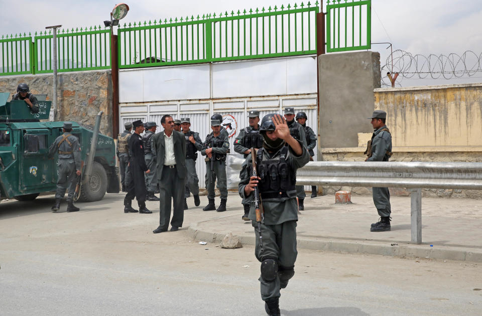 Afghan police forces stand in front of the main gate of Cure Hospital in Kabul, Afghanistan, Thursday, April 24, 2014. (AP Photo/Massoud Hossaini)