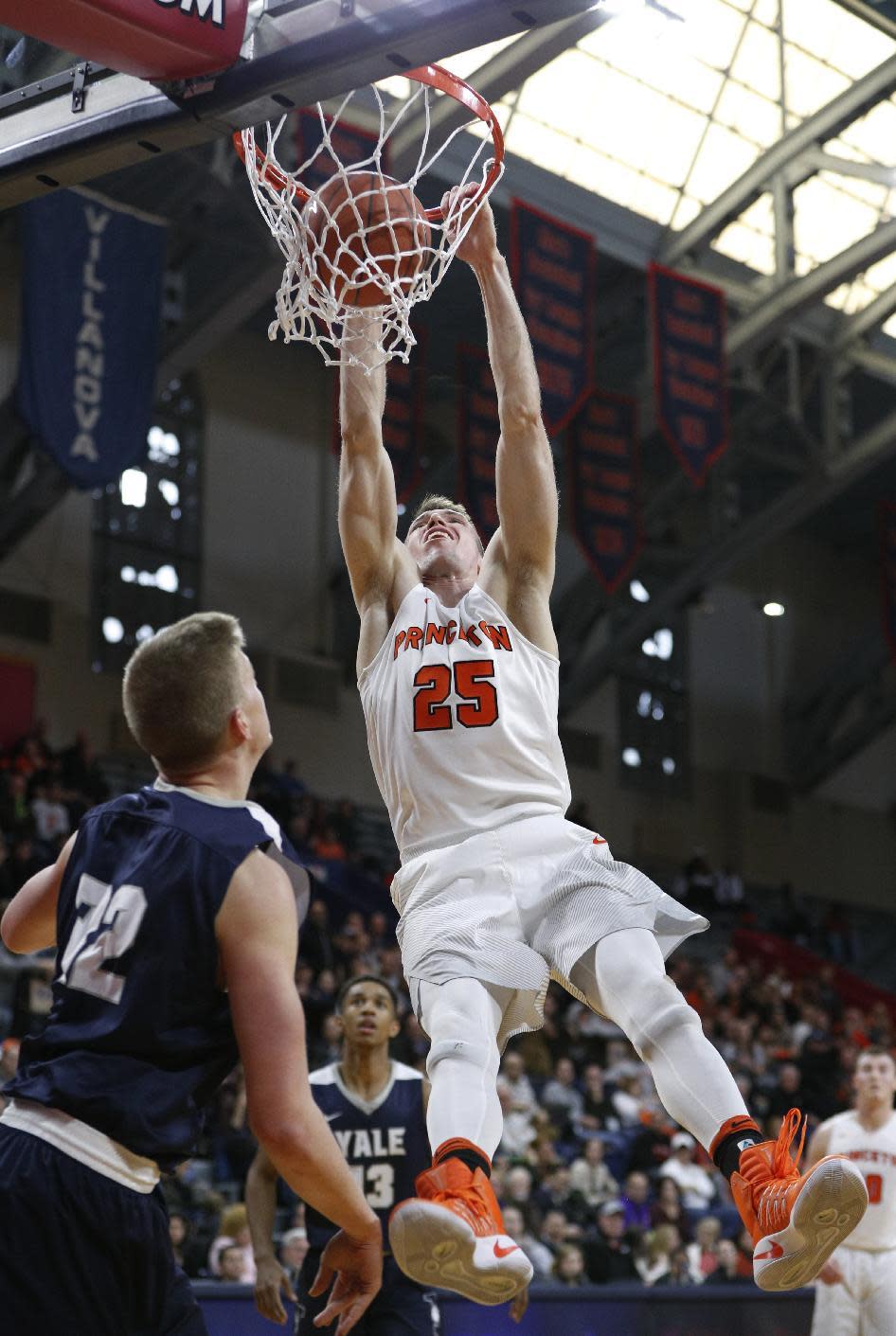 Princeton's Steven Cook, right, dunks the ball with Yale's Blake Reynolds, left, looking on during the first half of an NCAA college basketball championship game in the Ivy League Tournament, Sunday, March 12, 2017, in Philadelphia. (AP Photo/Chris Szagola)