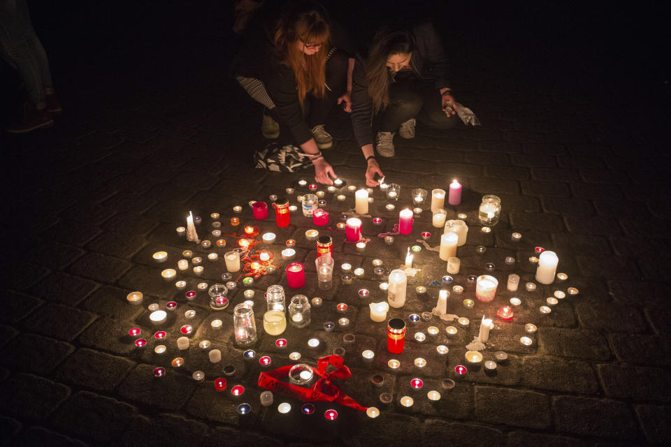 <p>In this Saturday, April 7, 2018 photo people light candles in Muenster, western Germany where a van crashed into people drinking outside a popular bar von on Saturday afternoon, killing two people and injuring 20 others before the driver of the vehicle shot and killed himself inside it. (Photo: Friso Gensch/dpa via AP) </p>