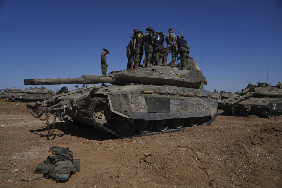 Israeli soldiers work on armored military vehicles at a staging ground near the Israeli-Gaza border, in southern Israel, Wednesday, May 8, 2024. (AP Photo/Tsafrir Abayov)