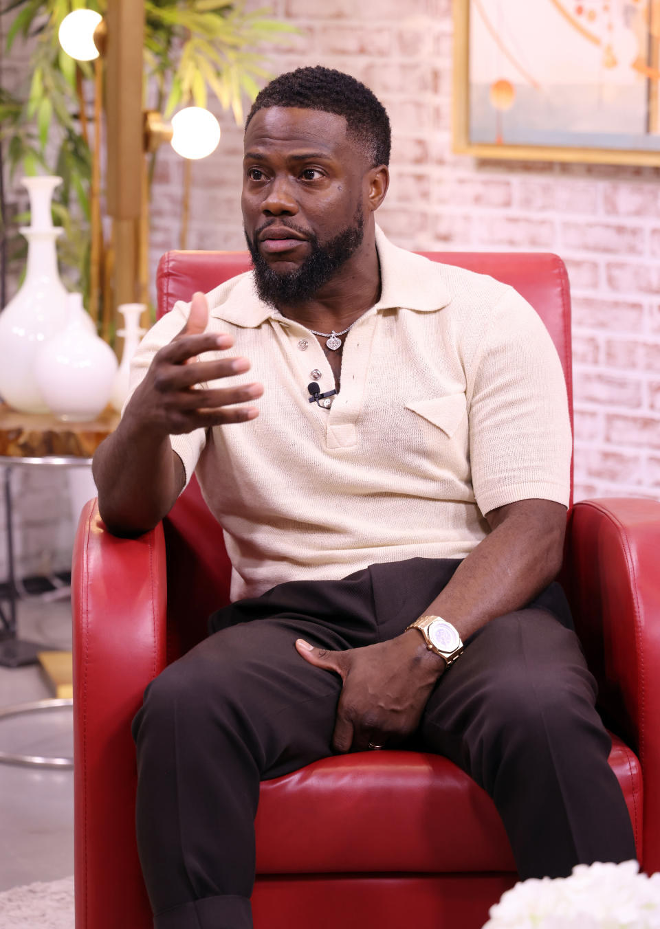 Kevin seated on a chair, gesturing with his hand during a discussion