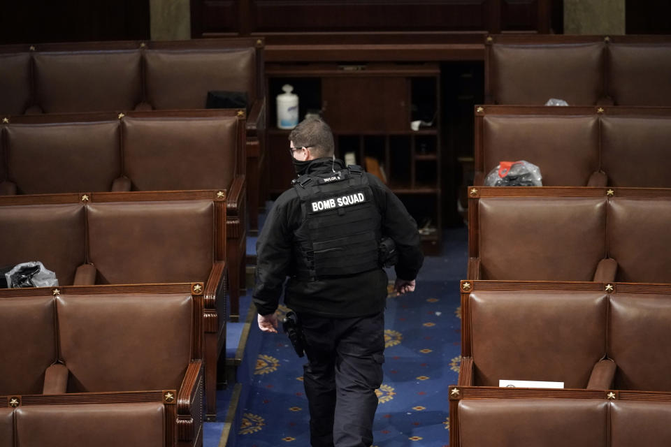 FILE - A member of the bomb squad walks on the House floor after rioters who support President Donald Trump broke into the U.S. Capitol on Jan. 6, 2021, in Washington. Intelligence reports compiled by the U.S. Capitol Police in the days before last year's insurrection envisioned only an improbable or remote risk of violence, even as other assessments warned that crowds of potentially tens of thousands of pro-Trump demonstrators could converge in Washington to create a dangerous situation. (AP Photo/J. Scott Applewhite, File)