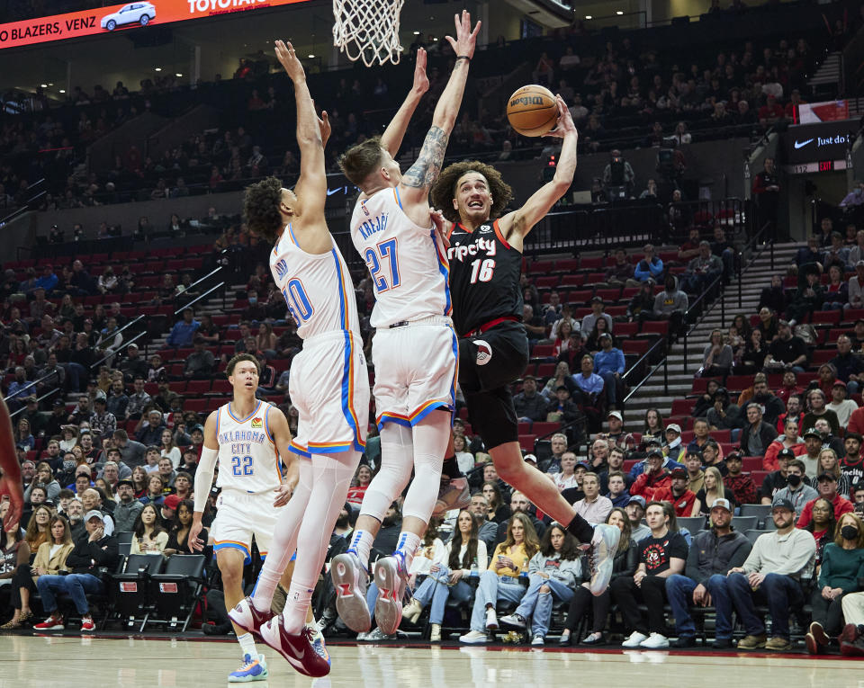 Portland Trail Blazers guard CJ Elleby, right, shoots over Oklahoma City Thunder guard Vit Krejci, center, and center Olivier Sarr during the first half of an NBA basketball game in Portland, Ore., Monday, March 28, 2022. (AP Photo/Craig Mitchelldyer)