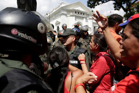 Supporters of Venezuela's President Nicolas Maduro shout slogans in front of Venezuelan National Guard members, outside the National Assembly building during a session in Caracas, Venezuela October 27, 2016. REUTERS/Marco Bello