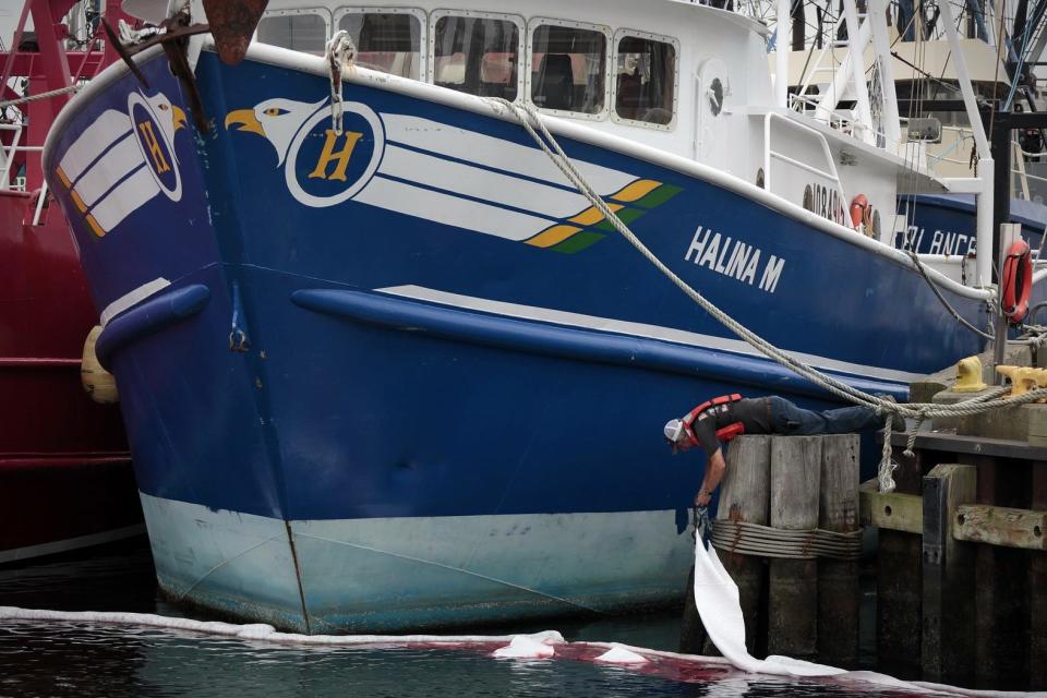 Myron Clark of Frank Corp. Environmental places absorbsion pads in this 2013 file photo to soak up an oil spill in New Bedford Harbor. [PETER PEREIRA/THE STANDARD-TIMES/SCMG]