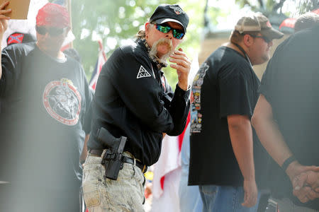 Members of the Ku Klux Klan openly wear firearms as they rally in opposition to city proposals to remove or make changes to Confederate monuments in Charlottesville, Virginia, U.S. July 8, 2017. REUTERS/Jonathan Ernst