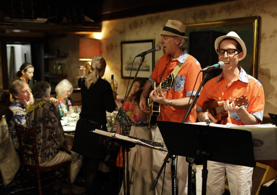 In this photo taken Friday, March 23, 2012, winemaker Judd Finkelstein, right, of Judd's Hill winery, plays his ukulele with his band during a winery luau at Trader Vic's restaurant in Emeryville, Calif. Don’t be surprised if Finkelstein serenades you with a ukulele. Playing the uke is one of his passions, he performs with his group Maikai Gents featuring The Mysterious Miss Mauna Loa. (AP Photo/Eric Risberg)
