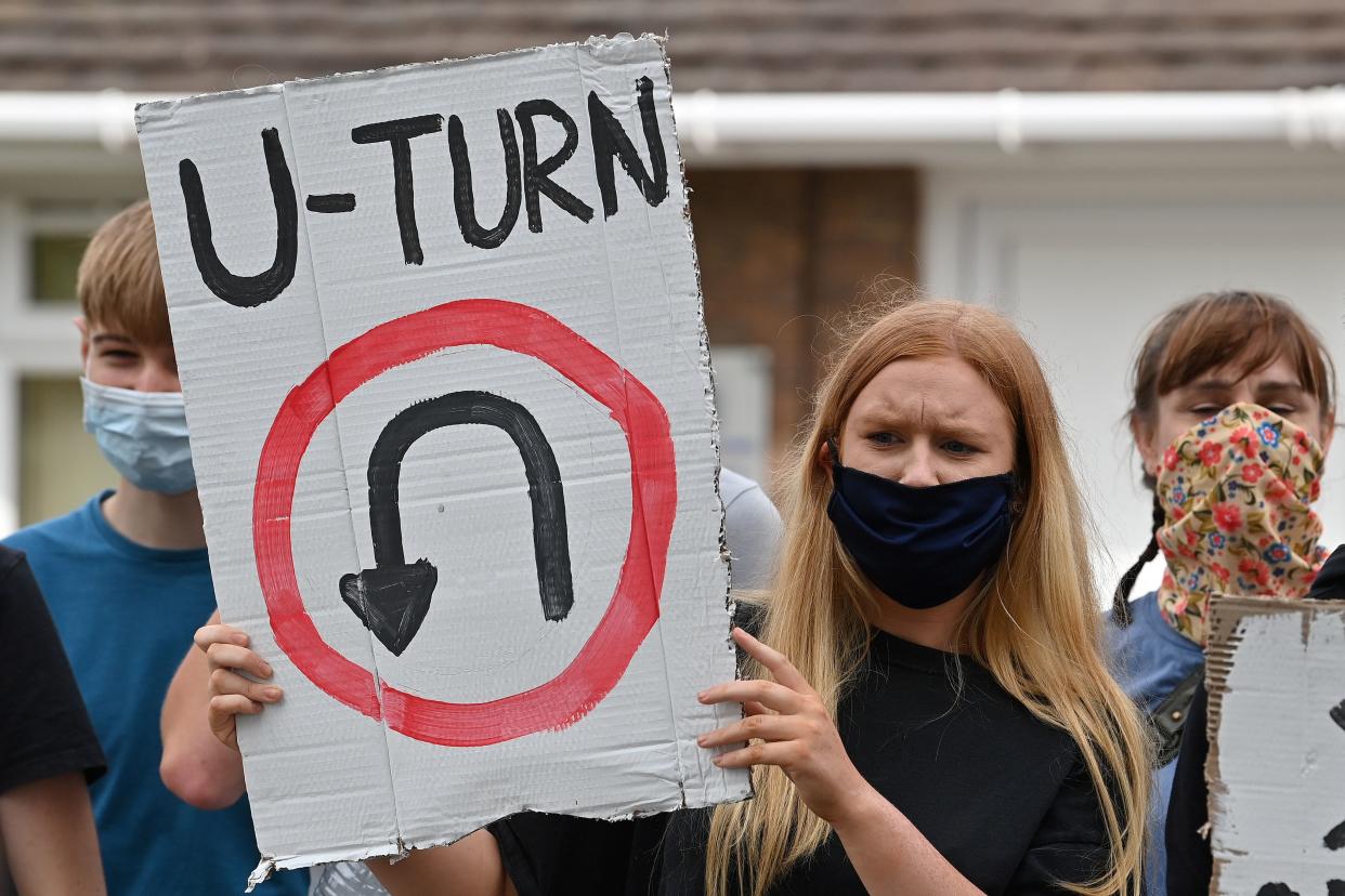 A student holds a placard reading "u-turn" as she takes part in a protest march from Codsall Community High School to the constituency office of Gavin Williamson, Conservative MP for South Staffordshire and Britain's current Education Secretary, in Codsall near Wolverhampton, central England on August 17, 2020, to demonstrate against the downgrading of A-level results. - Britain's government announced a u-turn Monday, meaning that A-level students in England will be see their grades increased. Williamson apologised to students and parents affected by "significant inconsistencies" with the grading process introduced after exams were cancelled due to COVID-19. (Photo by Paul ELLIS / AFP) (Photo by PAUL ELLIS/AFP via Getty Images)