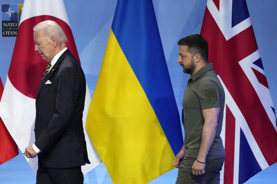 FILE -United States President Joe Biden, left, and Ukraine's President Volodymyr Zelenskyy pass by flags of G7 countries prior to an address by G7 leaders and Ukraine's President Volodymyr Zelenskyy during a NATO summit in Vilnius, Lithuania, Wednesday, July 12, 2023. United States President Joe Biden and his counterparts meet in Washington for a three-day summit beginning Tuesday, July 9, 2024 to mark the military alliance's 75th anniversary, with Russian troops pressing their advantave along Ukraine's eastern front in the third year of war. (AP Photo/Pavel Golovkin, File)