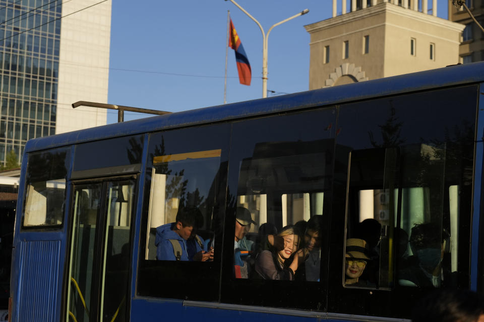 Residents ride a public bus past a Mongolian flag in Ulaanbaatar, Mongolia on Monday, Aug. 28, 2023. When Pope Francis travels to Mongolia this week, he will in some ways be completing a mission begun by the 13th century Pope Innocent IV, who dispatched emissaries east to ascertain the intentions of the rapidly expanding Mongol Empire and beseech its leaders to halt the bloodshed and convert. (AP Photo/Ng Han Guan)