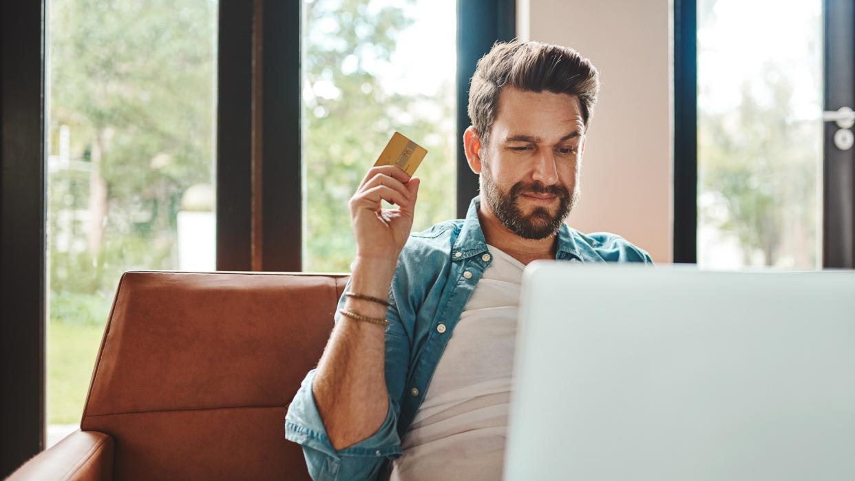 Cropped shot of a handsome young man shopping online while chilling on the sofa at home.