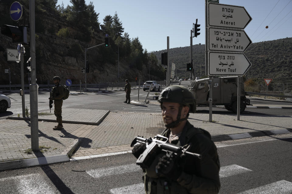 Israeli soldiers stand guard next to the scene of a Palestinian shooting attack, near Wadi al-Haramiya, West Bank, Sunday, Jan. 7, 2024. A Palestinian resident of Jerusalem who presumably was mistaken by the assailants as an Israeli because of the Israeli car license plates was fatally shot in the shooting, the Magen David Adom rescue service said. (AP Photo/Leo Correa)