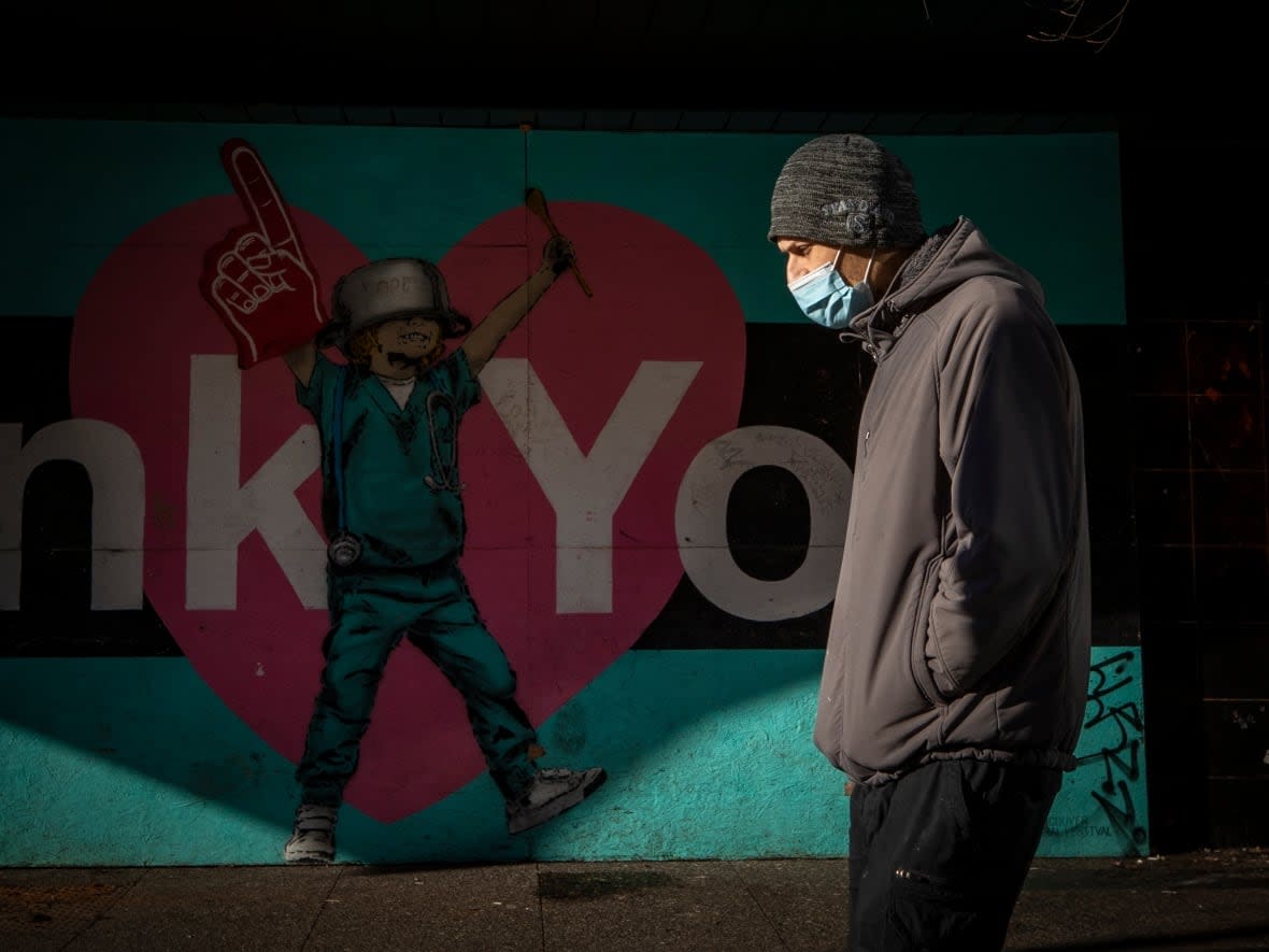 A pedestrian passes a mural thanking health-care workers in downtown Vancouver, British Columbia on Thursday, Jan. 27, 2022.  (Ben Nelms/CBC - image credit)