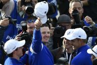 Team Europe players Rory McIlroy (L) and Justin Rose (C) celebrate teammate Jamie Donaldson winning his match against U.S. player Keegan Bradley to retain the Ryder Cup for Europe on the 15th green during their 40th Ryder Cup singles golf match at Gleneagles in Scotland September 28, 2014. REUTERS/Toby Melville (BRITAIN - Tags: SPORT GOLF)