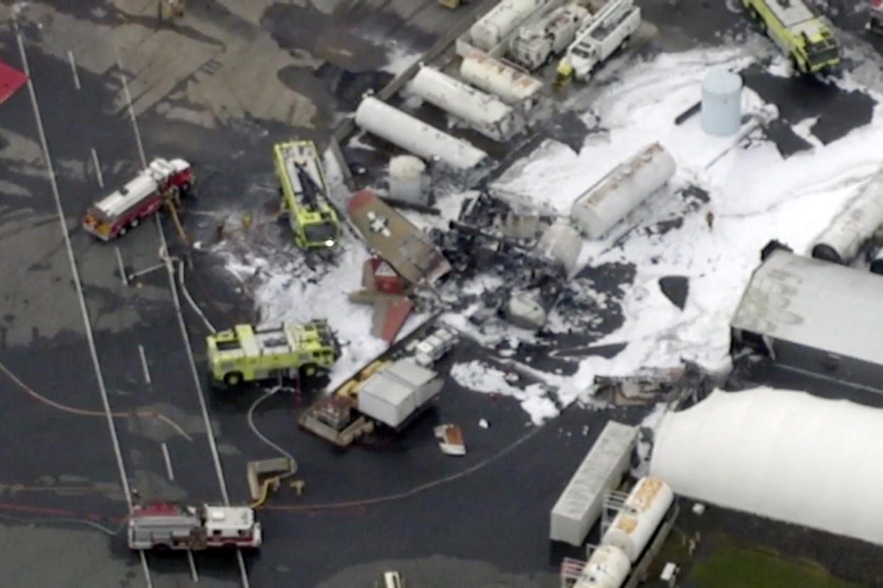 In this aerial image taken from video, emergency crews respond to where a World War II-era bomber B-17 plane crashed at Bradley International Airport in Windsor Locks, Conn., Wednesday, Oct. 2, 2019.  (WFXT Boston 25 News via AP)