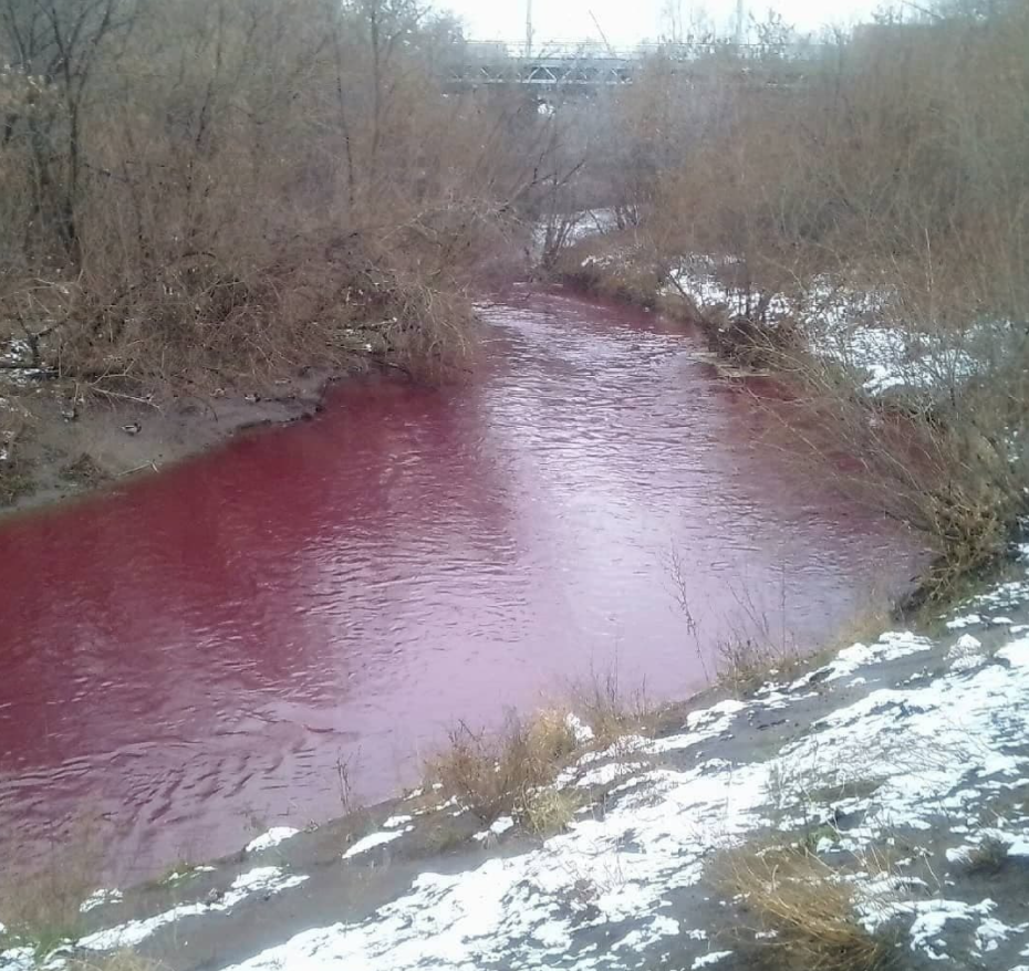 Water in the Iskitimka River is a light red colour as snow melts on the banks. 