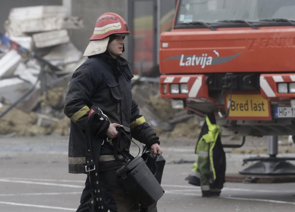 A firefighter walks past a collapsed supermarket in capital Riga