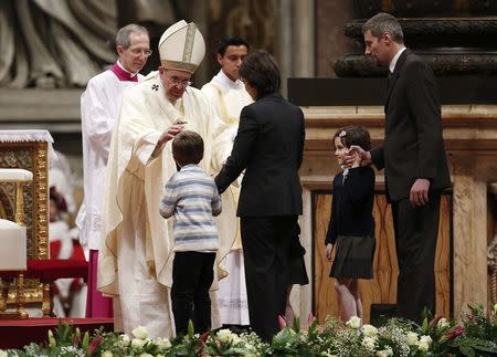 Pope Francis blesses a child as he celebrates a mass for the Virgin of Guadalupe in Saint Peter's Basilica at the Vatican December 12, 2014. REUTERS/Remo Casilli