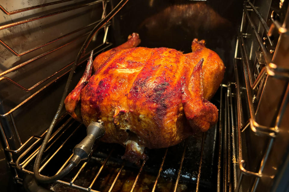 <p>A whole smoked chicken sitting inside of the GE Profile Smart Indoor Smoker.</p>
