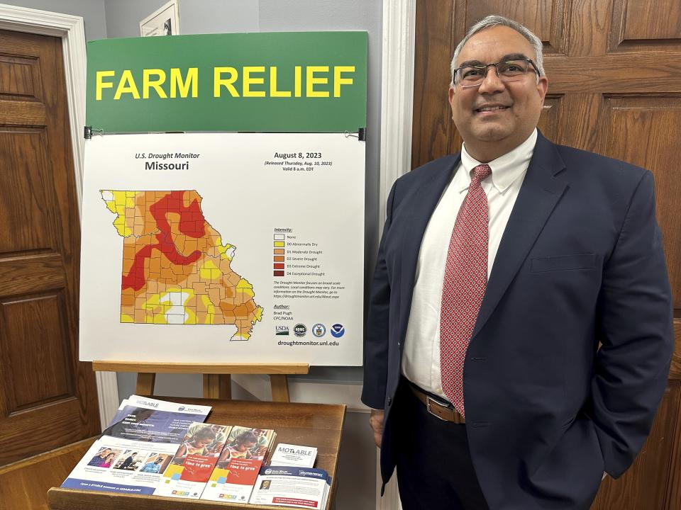 Missouri Treasurer Vivek Malek stands near a poster promoting drought conditions and state aid programs on Jan. 4, 2024, at his Capitol office in Jefferson City, Mo. Agricultural entities are among several categories of businesses that can receive low-interest loans backed by deposits of state funds made by the treasurer's office. Participation in such programs has grown in various states. (AP Photo/David A. Lieb)