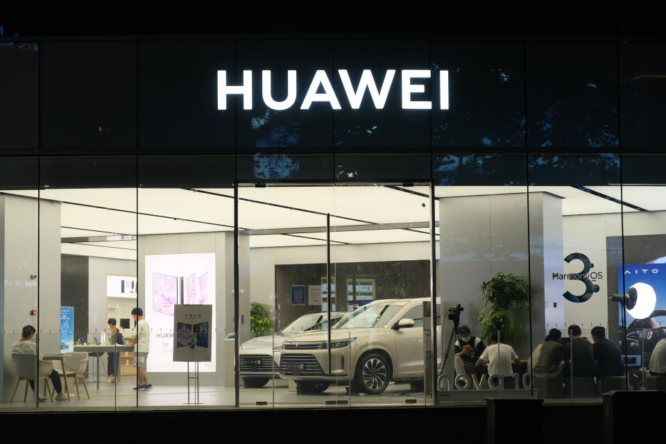 Shanghai,China-August 14th 2022: Huawei retail store logo and electric car. A Chinese electronic company