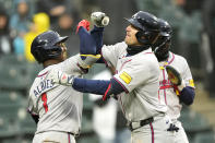 Atlanta Braves' Austin Riley, right, celebrates with Ozzie Albies after Riley's three-run home run off Chicago White Sox relief pitcher Dominic Leone in the eighth inning of a baseball game Monday, April 1, 2024, in Chicago. (AP Photo/Charles Rex Arbogast)