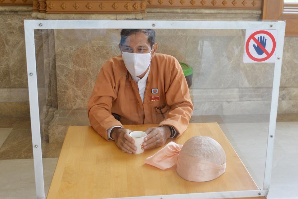 A member of Myanmar's parliament sits by himself while abiding by social distancing rules with a plastic divider at a table, in place to halt the spread of the COVID-19 coronavirus, at the Pyidaungsu Hluttaw parliament building in Naypyidaw on May 29, 2020. (Photo by Thet Aung / AFP) (Photo by THET AUNG/AFP via Getty Images)