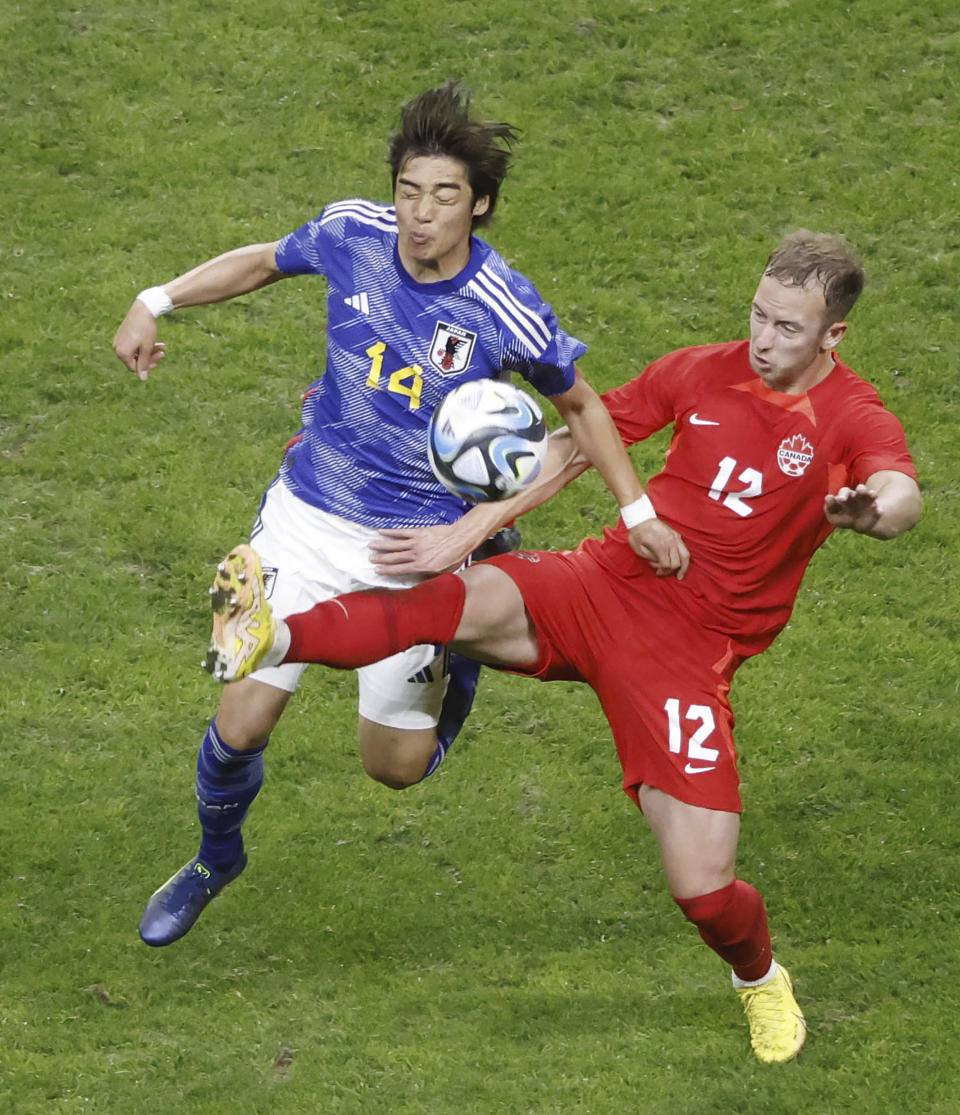 Harry Paton, right, of Canada, and Junya Ito of Japan vie for the ball during a friendly soccer match in Niigata, northern Japan, Friday, Oct. 13, 2023. (Kyodo News via AP)