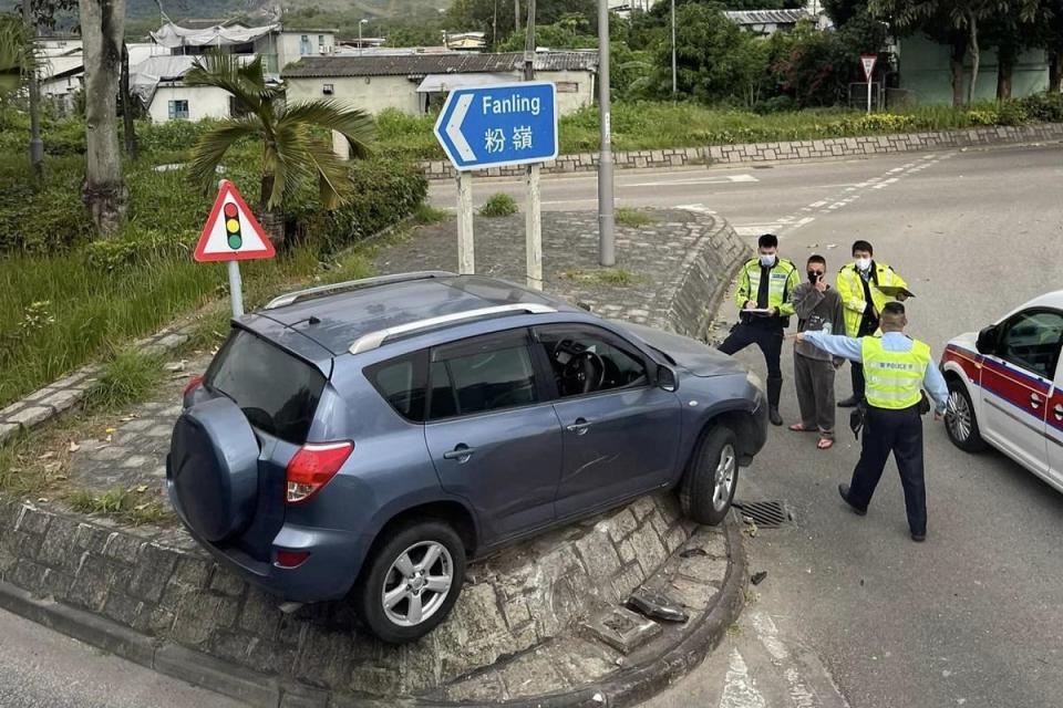 一輛私家車在沙頭角公路－龍躍頭段迴旋處失事，整輛車晾在路中石壆。(網民Siu Wai@FB群組「北區之友」)